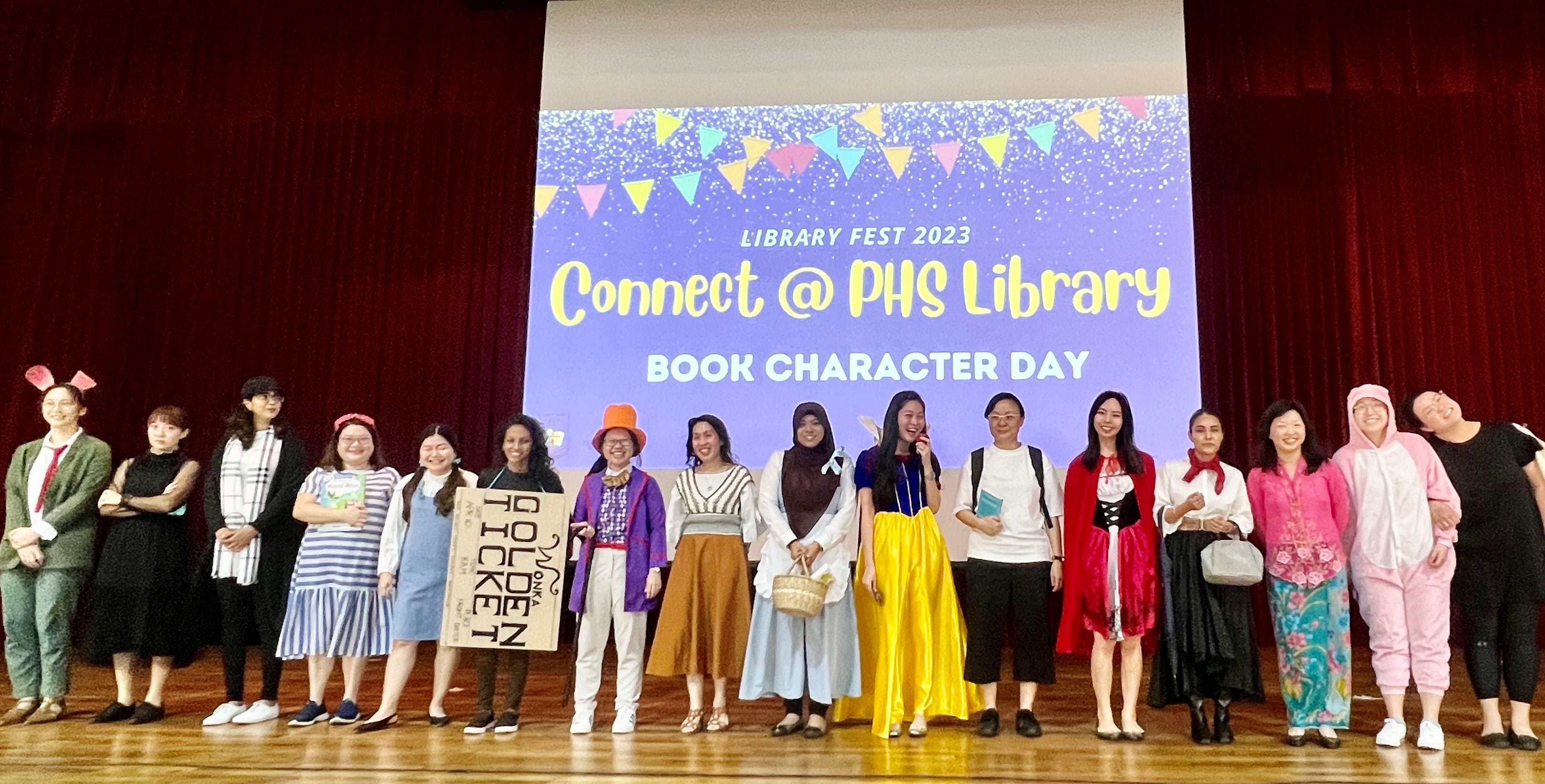 Group of people in book character costumes on a stage at Library Fest 2023 Book Character Day at PHS Library.